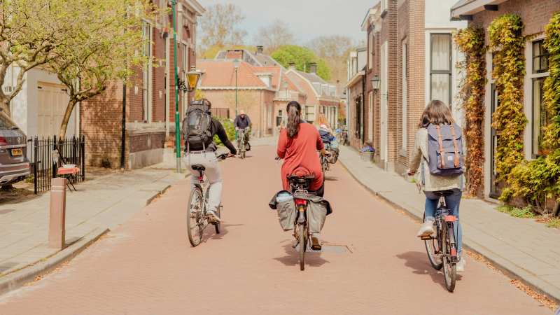 International students cycling to their driving lessons in English in Tilburg